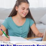 Little girl doing her homework at home and using a laptop