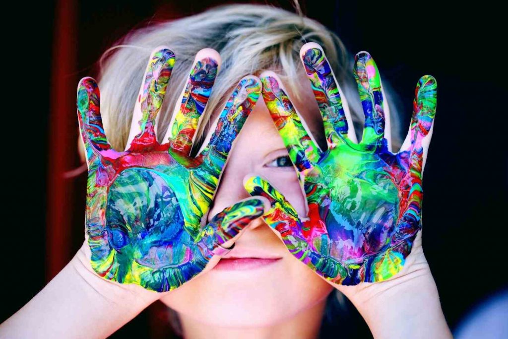 An image of a kid with colored hands