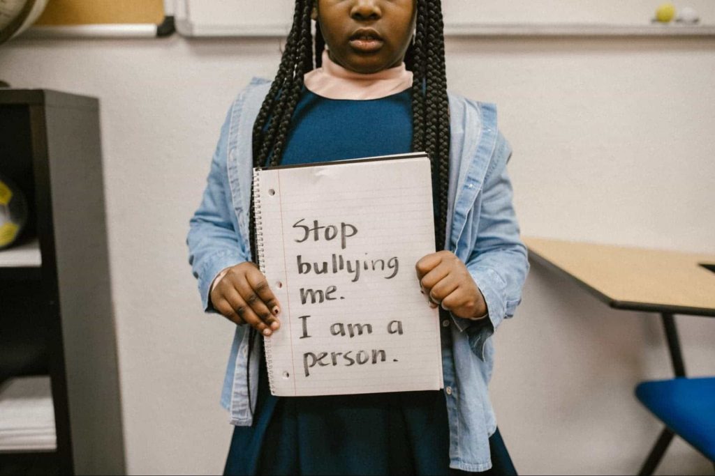 Achildinschool An image of a kid pleading to stop bullying