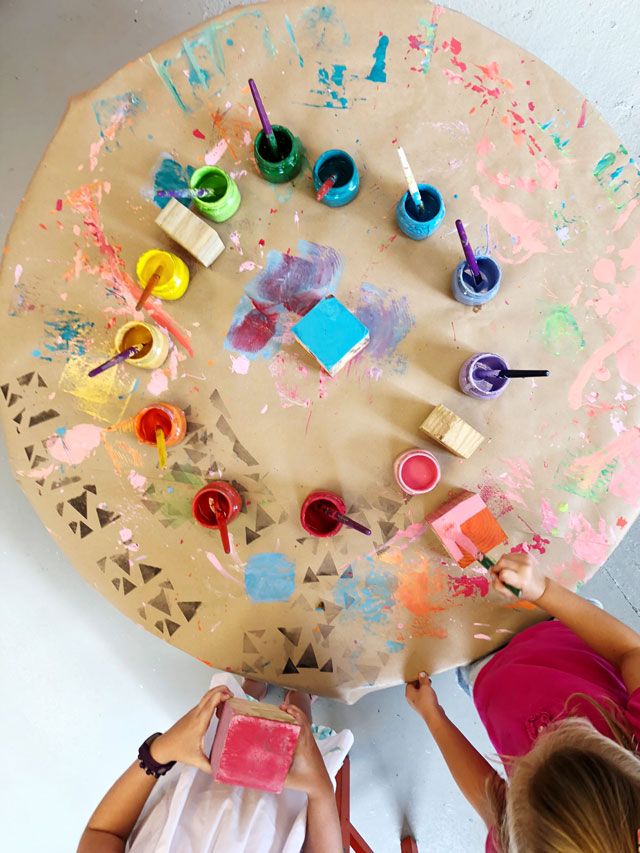 An image of a giant paper being painted by kids - indoor play for kids 