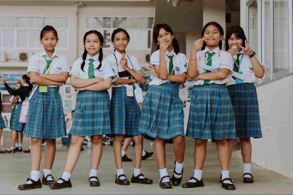 An image of girls standing together in school uniform 