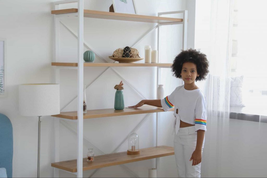 Image of a girl standing by a cabinet 