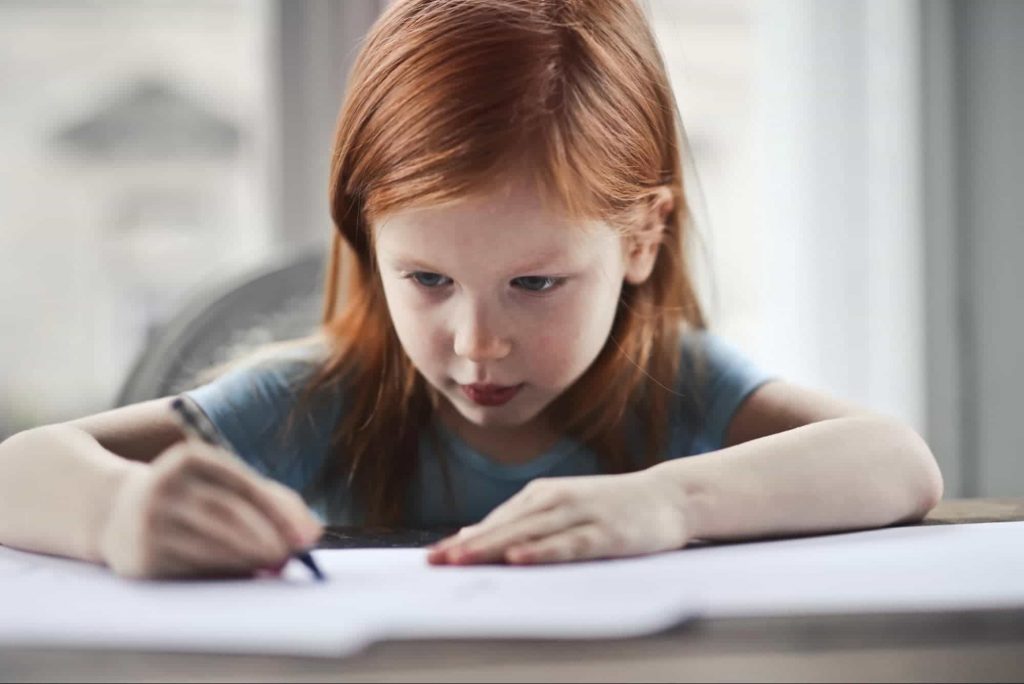 A kid writing - showing written expression as a learning disability 