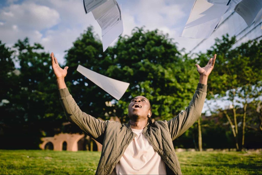 A student throwing notes in the air 