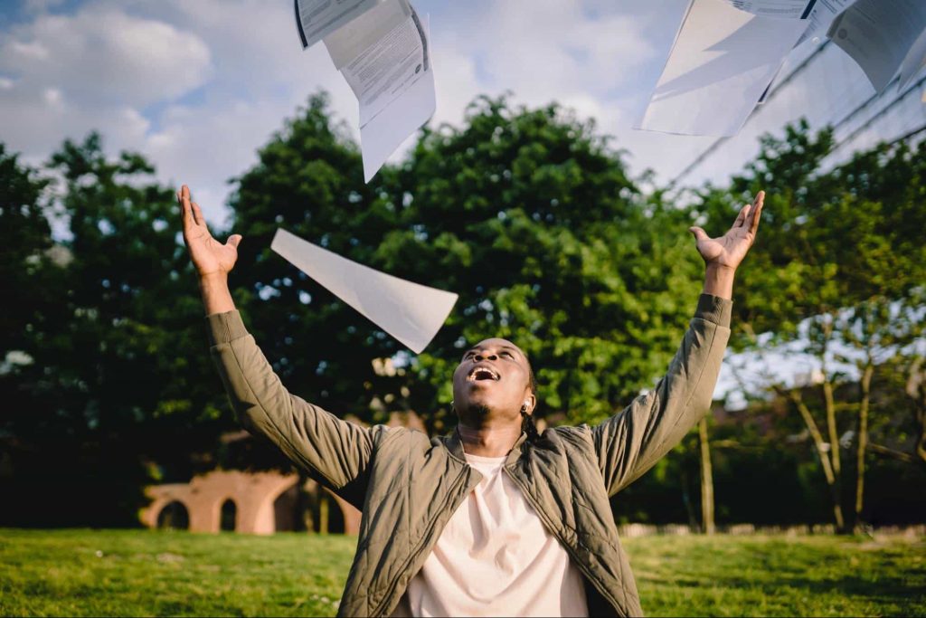 A student throwing notes in the air