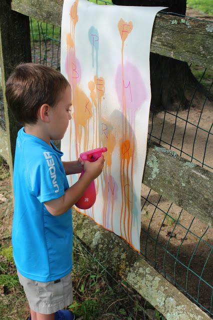 Child outside painting with paint gun painting ideas kids