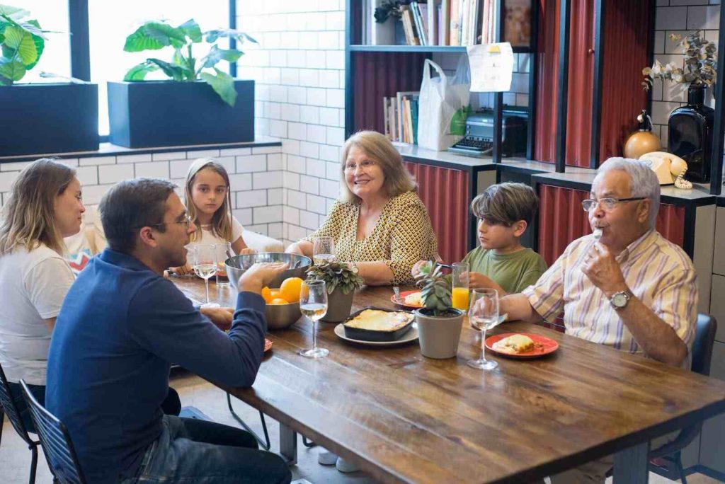 Family sitting together on dinner table talking mindfulness for kids