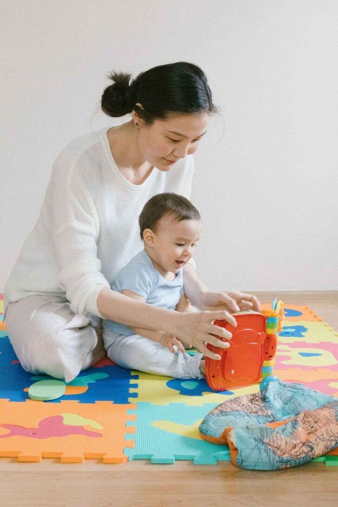 Mother playing with her child funny kids games with building blocks