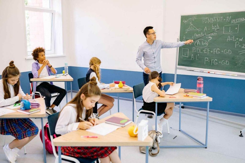 Teacher giving notes to students about Math puzzles Teacher giving notes to students about Math puzzles