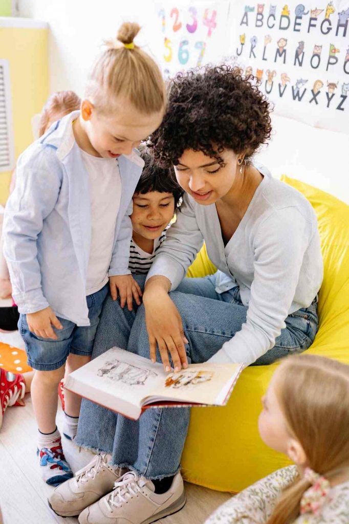 Teacher showing students illustration images in book brain teasers for kids