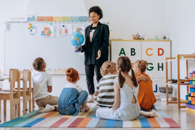 Teacher telling her students about the globe Auditory Learning