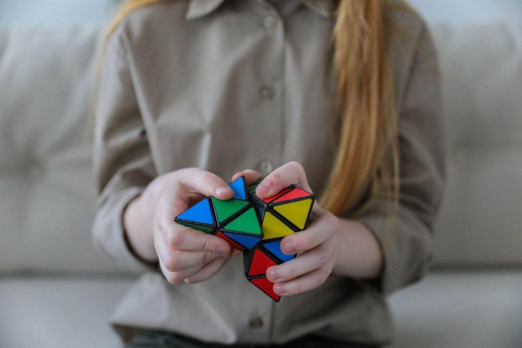 Young child solving Rubik's cube like puzzle math puzzle