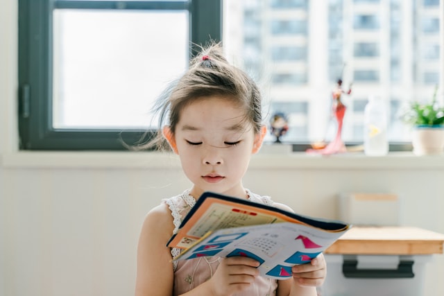 Young girl reading book phonological disorder