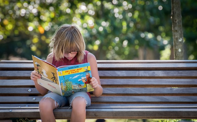 Young kid reading book comic phonological disorders Young kid reading book comic phonological disorder
