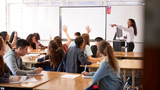 Image of a teacher in a class full of students
