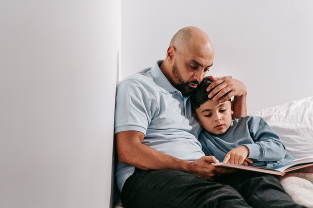 father sitting reading to child parallel parenting