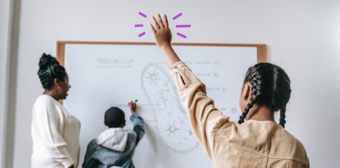 Image of student raising hands in the classroom