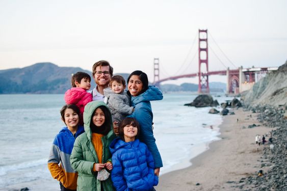 Family with smiles posing in front of Golden Gate Bridge things to do with kids near me Family with smiles posing in front of Golden Gate Bridge things to do with kids near me