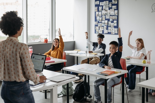 Teacher asking question and students raising hands philosophy of education