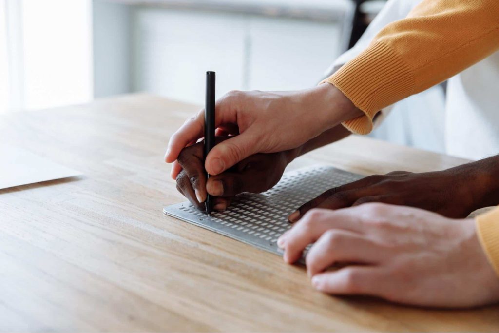 Image of someone writing with a pencil 