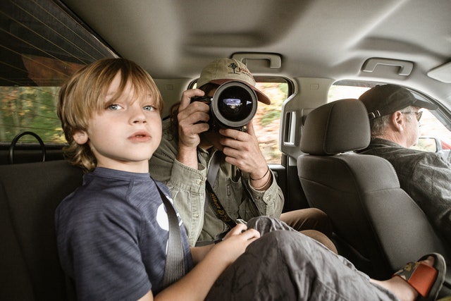 Boy in blue crew neck shirt man taking photo inside car games for kids