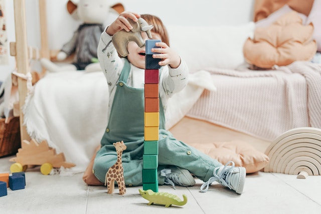 Child in long sleeve holding lego blocks What is taught to kids in preschool Child in long sleeve holding lego blocks What is taught to kids in preschool