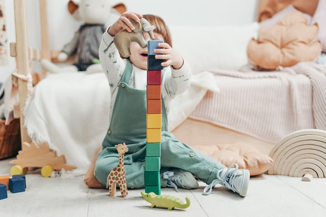 Child in long sleeve holding lego blocks What is taught to kids in preschool