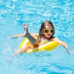 Child in swimming pool on ring toy kids swim Spring activities for preschoolers