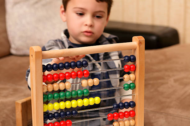 Preschool boy learning to count using an abacus