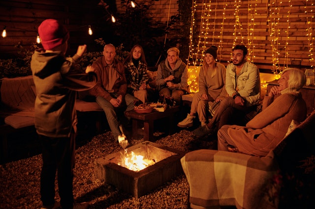 Family playing charades at bonfire in garden charades for kids