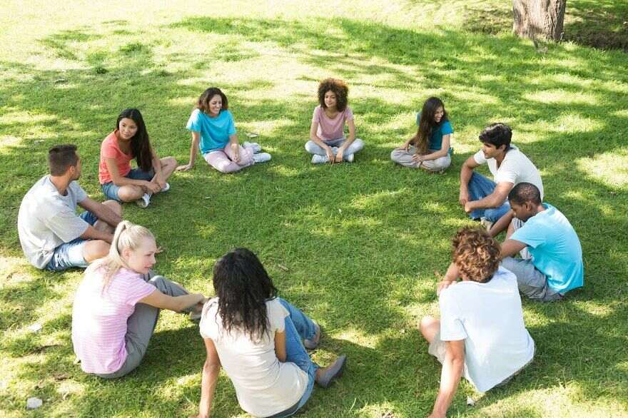 Friends sitting in a circle at park restorative practices in the classroom