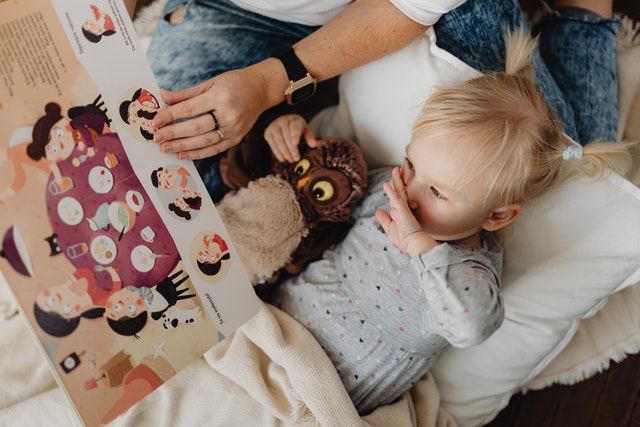 Girl lying down while reading a storybook Reading levels