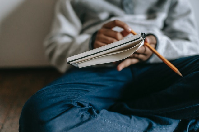 Kid writing in notebook journal prompts for kids