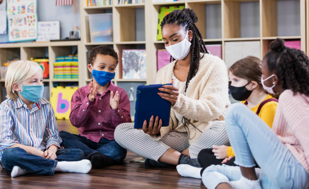 Preschool teacher students in class wearing masks teaching preschoolers