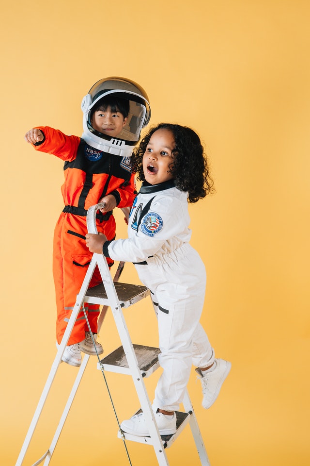Two small children on ladder wearing space suits kids positive affirmations