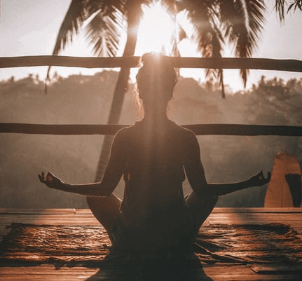 Woman Meditating during sunset in front of tree self care for teachers