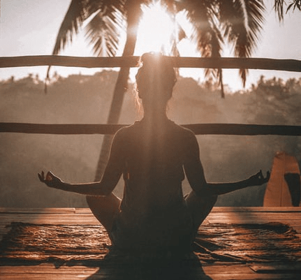 Woman Meditating during sunset in front of tree self care for teachers Woman Meditating during sunset in front of tree self care for teachers