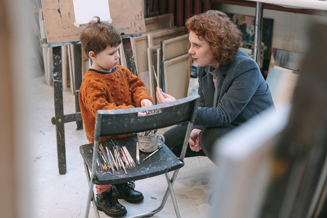 Woman teaching a boy about painting restorative practices in the classroom