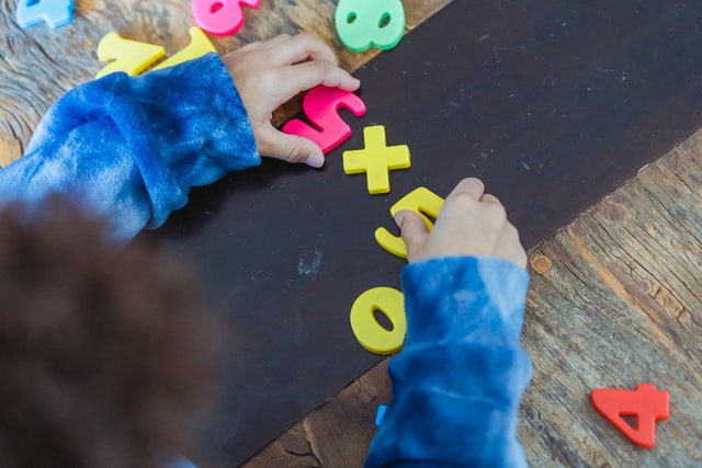 boy playing with toy numbers What is taught to kids in 2nd grade