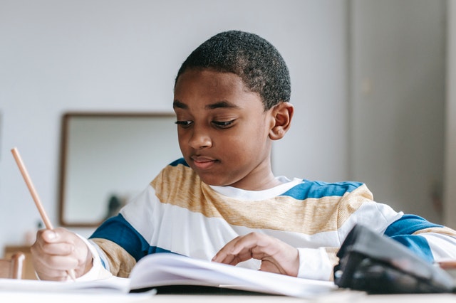 boy writing in notebook journal prompts for kids