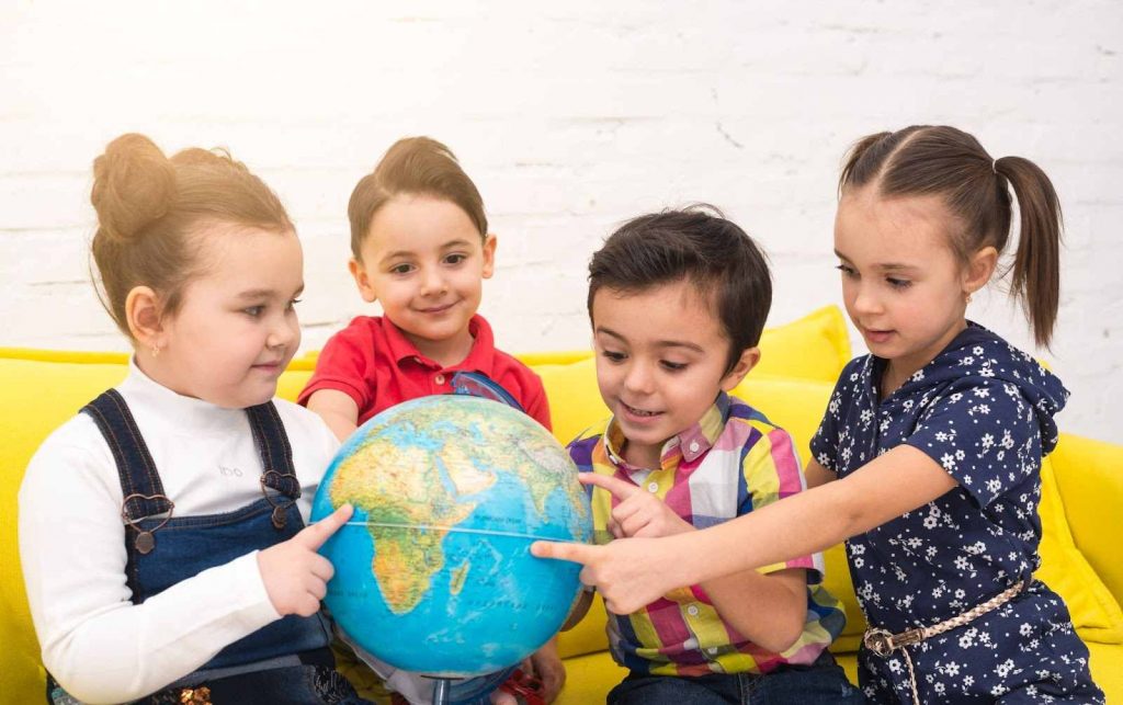 Kids pointing at a globe