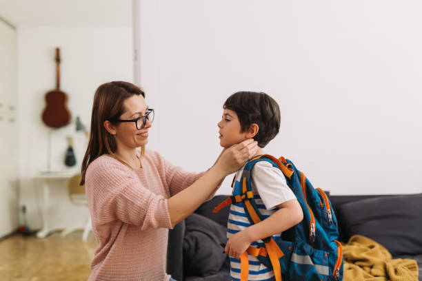 mother preparing her son for first day at school mother preparing her son for first day at school