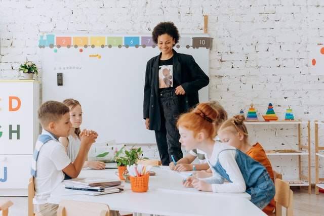 Children sitting on brown wooden chairs beside white table Healthy student centered learning environment