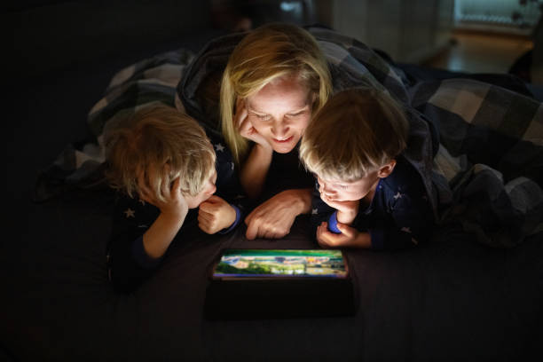 Family enjoying watching movie on tablet reading apps