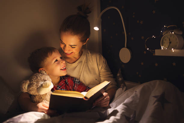 Mother and son laughing while reading bedtime stroy book reading websites for kids