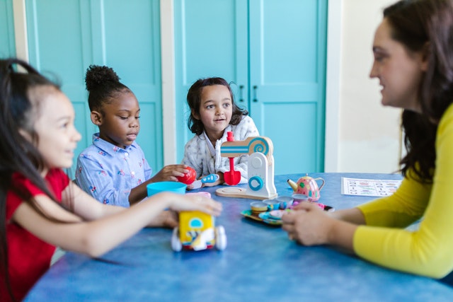 Teacher talking with her pupils What is taught to kids in 3rd grade