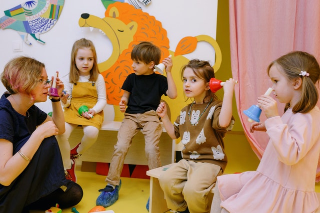 Teacher with her students holding different color bells Healthy student centered learning environment