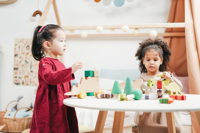 Two children playing a wooden toy scaffolding strategies