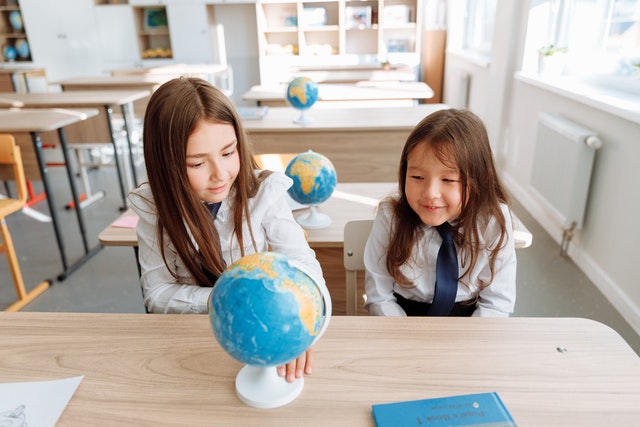 Two girls studying a globe scaffolding strategies