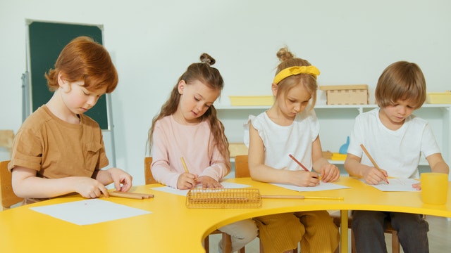 Elementary students writing on a paper